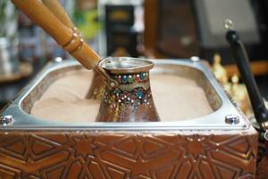 oben Aussicht von Herstellung traditionell Türkisch Kaffee auf Sand foto