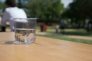 Wasser im ein Plastik Container auf ein Cafe Tabelle draussen foto