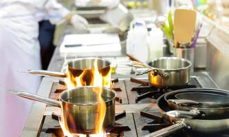 Koch bereitet Essen in der Küche zu, Koch kocht, Koch dekoriert Gericht foto