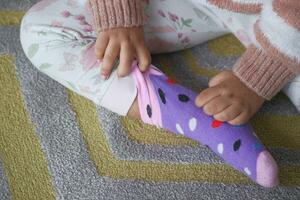 ein Kind versuchen zu entfernen ihr Socken foto