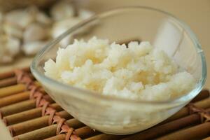 Nahaufnahme von gehacktem Knoblauch auf einem Holzlöffel foto