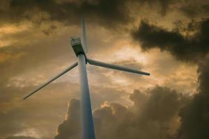 Windkraftanlage vor einem Himmel mit weißen Wolken foto