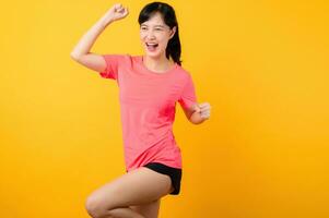 Porträt schön jung asiatisch Sport Fitness Frau glücklich Lächeln tragen Rosa Sportbekleidung posieren Übung Ausbildung trainieren isoliert auf Gelb Studio Hintergrund. Wohlbefinden und gesund Lebensstil Konzept. foto