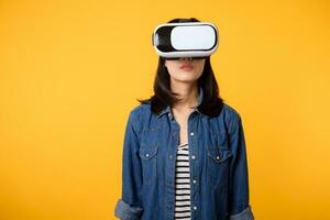 jung asiatisch Frau erhalten erfahren tragen virtuell Wirklichkeit Headset Spiel Unterhaltung isoliert auf Gelb Hintergrund. Gewinner von Cyber Zukunft Video Spiel Konzept. foto