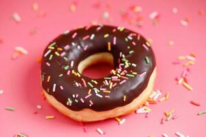 sortiert Donuts mit Schokolade Glasur, Belag Sträusel Donuts bunt Vielfalt und Vielfalt von Aromen mischen von multi farbig Süss Donuts mit gefrostet bestreut auf Rosa Hintergrund. oben Aussicht foto