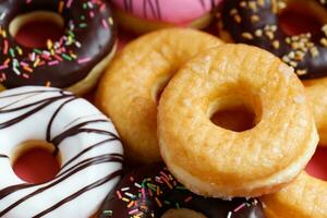 sortiert Donuts mit Schokolade Glasur, Belag Sträusel Donuts bunt Vielfalt und Vielfalt von Aromen mischen von multi farbig Süss Donuts mit gefrostet bestreut auf Rosa Hintergrund. oben Aussicht foto