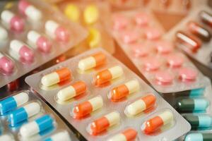 nahaufnahme pharmazeutika antibiotika pillen medizin in blisterpackungen. bunter antibakterieller pillen-apothekenhintergrund. kapsel pille medizin antimikrobielle medikamentenresistenz. Pharmaindustrie foto