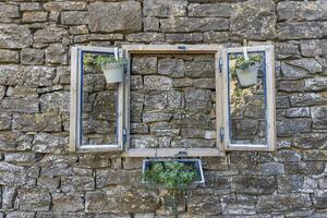 Bild von ein Fälschung Fenster wie Dekoration auf ein natürlich Stein Mauer foto