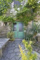 Bild von ein Eingang Bereich zu ein uralt Haus mit Klettern Pflanzen und ein Stein ruhen Platz foto