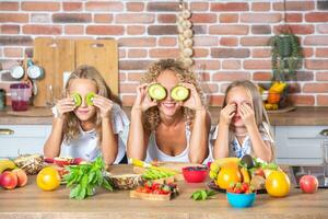 Mutter und Töchter Kochen zusammen im das Küche. gesund Essen Konzept. Porträt von glücklich Familie mit frisch Smoothies. glücklich Schwestern. foto