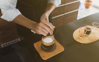 Barista, der Kunstkaffee Latte im Café macht foto