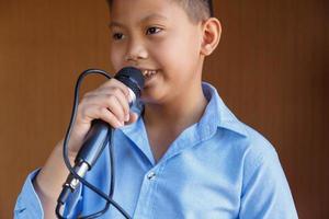 Jungen mit Mikrofon lernen singen foto