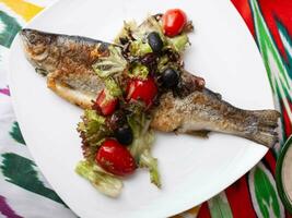 gebraten Fisch mit ein Kissen von gedünstet Gemüse. asiatisch Stil foto