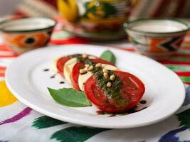 Italienisch Caprese Salat mit Tomaten, Mazzarella Käse und Balsamico Soße. asiatisch Stil foto