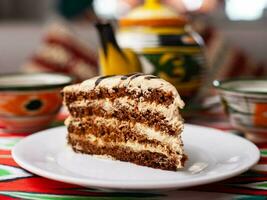 Dessert Schokolade Kuchen mit Beige Sahne im orientalisch Stil auf ein Dach mit ein Teekanne und ein Tasse zum Tee. foto