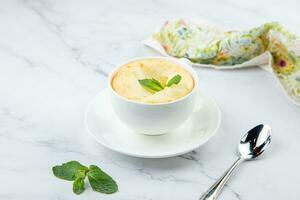 Tasse von Kaffee mit Schaum und ein Zweig von Minze auf ein Marmor Hintergrund foto