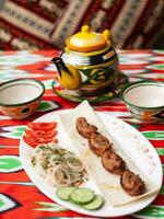 Hähnchen Kebab Holzkohle gegrillt Hähnchen Brust serviert mit Gemüse, eingelegt Zwiebeln, Lavash Brot und orientalisch Soße foto