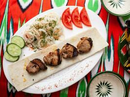 Hähnchen Kebab Holzkohle gegrillt Hähnchen Brust serviert mit Gemüse, eingelegt Zwiebeln, Lavash Brot und orientalisch Soße foto