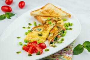 Frühstück von Eier und Gemüse mit Kirsche Tomaten und Scheiben von Brot im ein Weiß Teller Seite Aussicht foto