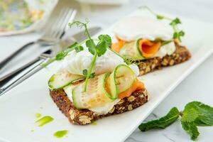 Häppchen auf schwarz Brot mit Käse, rot Fisch, Kräuter und Gurke Seite Aussicht foto