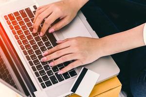 Nahaufnahme von Frauenhänden mit Laptop-Computer mit Kreditkarte