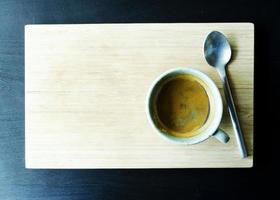 heiße Kaffeetassen und Löffel auf Holzplattenhintergründen oben foto