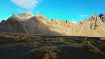 stokksnes Strand und Vestrahorn Berge, majestätisch schön Landschaft auf natürlich schwarz Sand Strand. skandinavisch Halbinsel Landschaft von fest Hügel und Ozean Wellen, isländisch Natur. foto