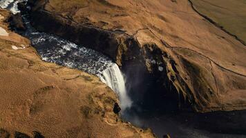 Drohne Schuss von Skgafoss Wasserfall Bildung schön Regenbogen, isländisch Landschaft mit nordisch Natur. spektakulär skandinavisch Kaskade fließend Nieder aus von Klippen, Panorama- Sicht. schleppend Bewegung. foto