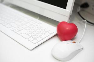 rotes Herz im Büro mit Computertischset foto
