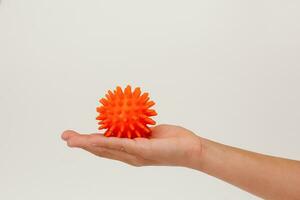 Kind Hand halten Orange stachelig Ball zum Massage foto