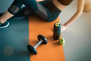 Fitnessfrau mit gesunden Trainingsgeräten im Fitnessstudio foto