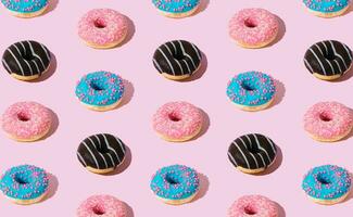 kreativ Muster von bunt Donuts auf Pastell- Rosa Hintergrund. minimal Konzept. modisch Donuts Muster. lecker Essen Komposition. Donuts ästhetisch Hintergrund. foto