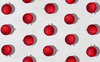 kreativ modisch Muster gemacht mit rot Weihnachten Kugeln auf schneebedeckt Hintergrund. minimal Weihnachten oder Neu Jahr Konzept. Winter Ferien Idee. eben legen Komposition. oben von Sicht. foto