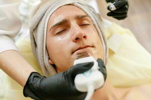 das Kosmetikerin macht das Verfahren Ultraschall- Gesicht Peeling foto