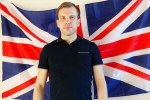 Porträt des jungen Mannes gegen britische Flagge foto