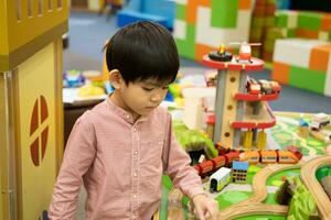 wenig asiatisch Junge spielen mit Spielzeug Auto im das Kinder- abspielen Park foto