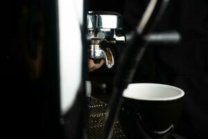 Espresso tropfen Schuss mit doppelt Tülle Siebträger von Kaffee Maschine. Kaffee Bohnen Braten Prozess Espresso Maschine. Kaffee tropfen Kommen aus von das Tülle. foto