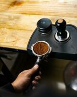 Kaffee Espresso manipulieren. Barista vorbereiten zu anwenden Druck auf Kaffee manipulieren. Vorbereitung von Stampfen tamp Drücken Sie auf Boden Kaffee zu machen ein Espresso. foto