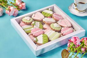 Box mit Lebkuchen Kekse mit bunt Zucker Glasur mit Tasse von Kaffee und Rosen foto