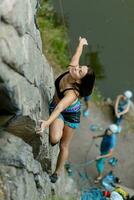 ein Mädchen klettert ein Felsen. Frau beschäftigt, verlobt im extrem Sport. foto