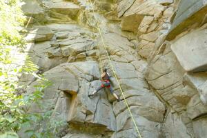 ein Mädchen klettert ein Felsen. Frau beschäftigt, verlobt im extrem Sport. foto