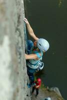 ein Mädchen klettert ein Felsen. Frau beschäftigt, verlobt im extrem Sport. foto