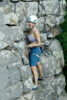 ein Mädchen klettert ein Felsen. Frau beschäftigt, verlobt im extrem Sport. foto