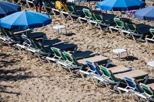 Deck Stühle Über das Sand im ein idyllisch Strand im Ibiza, balearisch Inseln, Spanien foto