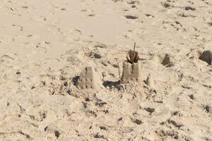 diese schön braun Sand Schloss ist Sitzung Hier auf diese Strand. das Fort sitzt Hier mit Fußabdrücke alle um. foto