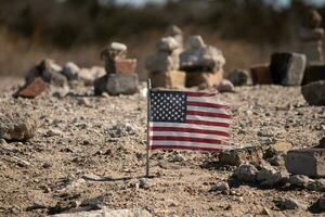 diese schön amerikanisch Flagge war im diese Sand Monument Das war erstellt auf das Strand. ich geliebt das aussehen von diese weht im das Wind mit alle das Steine gestapelt oben um Es. schien sehr patriotisch. foto