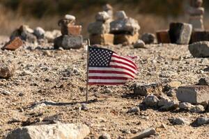 diese schön amerikanisch Flagge war im diese Sand Monument Das war erstellt auf das Strand. ich geliebt das aussehen von diese weht im das Wind mit alle das Steine gestapelt oben um Es. schien sehr patriotisch. foto