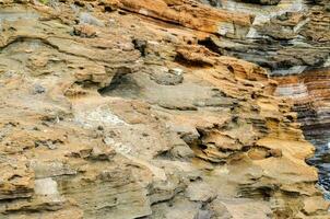 ein Mann ist Stehen auf ein Cliff in der Nähe von das Ozean foto