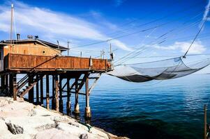 ein Angeln Netz ist hängend von ein hölzern Seebrücke foto