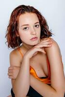 Porträt von attraktiv Mädchen im Orange Kleid im das Studio foto